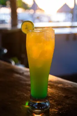 a drink sitting on a table with a lemon slice in it at Tintipan Hotel in Tintipan Island