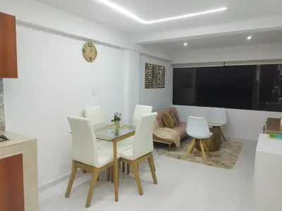 a dining room with a table and white chairs at Apartamento moderno frente al mar in Cartagena de Indias