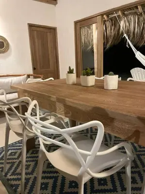 a wooden table with four white chairs in a room at Casita del Viento in San Bernardo del Viento