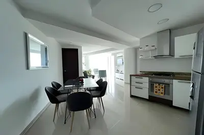 a white kitchen with a table and chairs in it at 2 Dormitorios Morros. Vista Ciénaga y salida playa in Cartagena de Indias