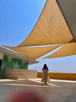 a woman walking past a building with awning at Hotel Paranawa in Baranoa