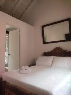 a bedroom with a bed with a mirror on the wall at EMMA HOTEL SAN DIEGO in Cartagena de Indias