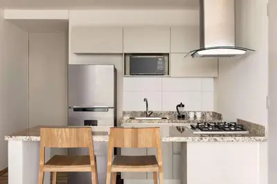 a kitchen with two chairs and a counter top at Wyndham Residences Santa Marta Aluna Beach Club in Santa Marta
