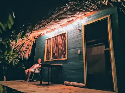 a man sitting in a chair in front of a table at Cabañas La Múcura in San Onofre