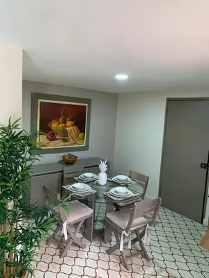 a dining room with a table and chairs and a painting at Apartahotel Edificio Baquero x5 Apto 201 in Barranquilla