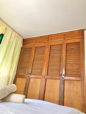a bedroom with a wooden wall with wooden shutters at Acogedor apartamento en bruselas in Cartagena de Indias