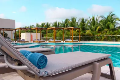 a swimming pool with a chaise lounge with a blue towel at Exclusiva casa en Baru con piscina y playa privada in Playa Blanca