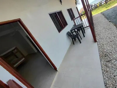 a balcony with two black chairs and a table at La Casa del Mar - Hotel Familiar en San Bernardo del Viento in San Bernardo del Viento