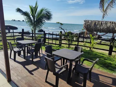 a deck with tables and chairs and the ocean at La Casa del Mar - Hotel Familiar en San Bernardo del Viento in San Bernardo del Viento