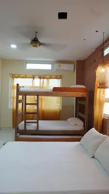 a room with two bunk beds and a table at Los Cayos Cabañas in Coveñas