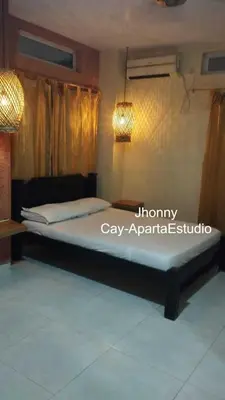 a bed in a bedroom with a light on the wall at Los Cayos Cabañas in Coveñas