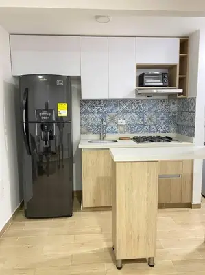 a kitchen with a black refrigerator and a sink at REFUGIO URBANO - Apartamento para descanso y trabajo remoto en Alameda del Río Barranquilla in Barranquilla