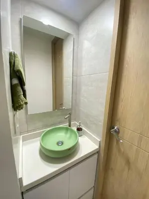 a bathroom with a green sink and a mirror at REFUGIO URBANO - Apartamento para descanso y trabajo remoto en Alameda del Río Barranquilla in Barranquilla