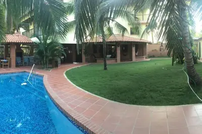 a resort with a swimming pool and a yard at Casa de playa Nijegi en Santa Veronica in Juan de Acosta