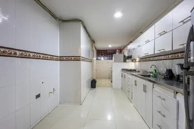 a large kitchen with white tile walls and white cabinets at APARTAMENTO CATALINA BOCAGRANDE 1b in Cartagena de Indias
