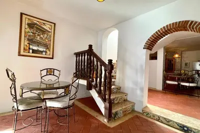 a dining room with a table and a staircase at Gorgeous 8 BR House w/ Pool in the Old City in Cartagena de Indias