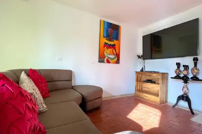 a living room with a couch and a flat screen tv at Gorgeous 8 BR House w/ Pool in the Old City in Cartagena de Indias