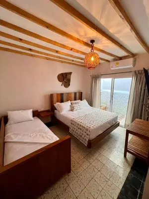 a bedroom with two beds and a large window at Colonial Beach Airport Hotel in Cartagena de Indias