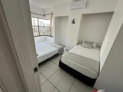 two beds in a small room with a window at BARLOVENTO in Cartagena de Indias