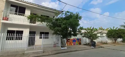 a white house with a white picket fence at Piantini Houses in Coveñas