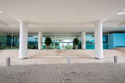 a large building with white columns and blue walls at Apartamento con terraza Frente al Mar in Cartagena de Indias
