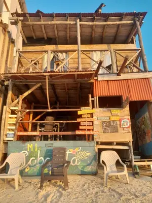 a building on the beach with two chairs at Mi Cabañita Guest House in Playa Blanca
