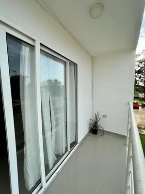 a white house with a large window on a balcony at Tu lugar ideal cerca al mar apartamento MyM in Coveñas