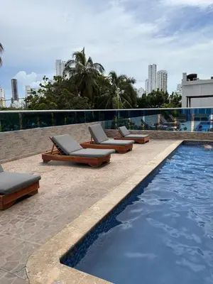 a row of lounge chairs next to a swimming pool at Fabuloso estudio con vista al laguito in Cartagena de Indias