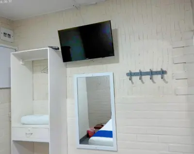 a bathroom with a mirror and a tv on a wall at Hotel Casa Boston Inn by Finerh in Barranquilla
