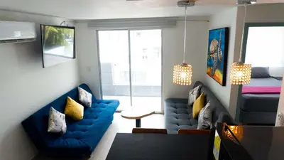 a living room with a blue couch and a bed at Apartamento en la Boquilla in Cartagena de Indias