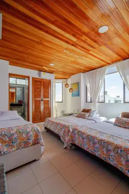 a bedroom with two beds and a wooden ceiling at Habitación para 3 a una cuadra de la playa y bahía in Cartagena de Indias
