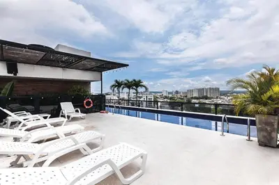 a balcony with white chairs and a swimming pool at Hotel Cartagena DC in Cartagena de Indias