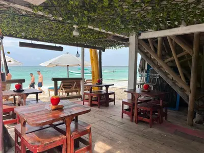 a restaurant with tables and chairs on the beach at AcapulcoBeach in Playa Blanca