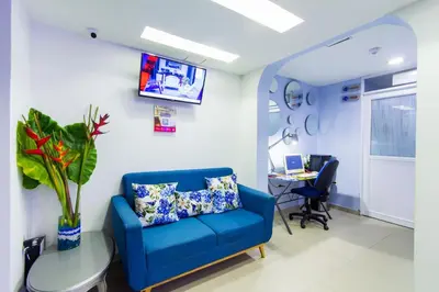 an office with a blue couch and a table at Azuán Suites Hotel By GEH Suites in Cartagena de Indias