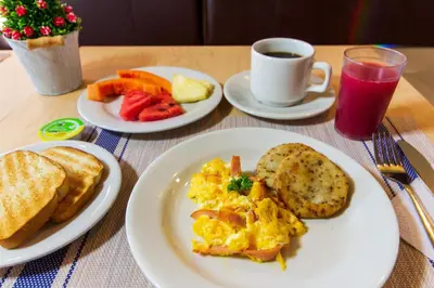 a table with plates of eggs and toast and a cup of coffee at Azuán Suites Hotel By GEH Suites in Cartagena de Indias