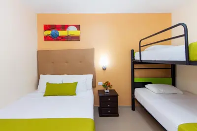 two beds in a room with a bunk bed at Azuán Suites Hotel By GEH Suites in Cartagena de Indias