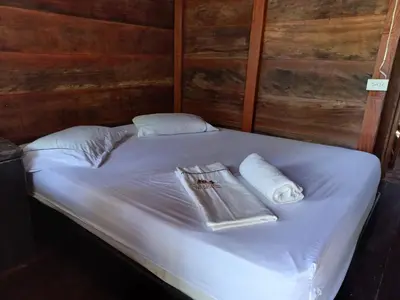 a bed with two towels and a book on it at Hugos Place Baru in Playa Blanca