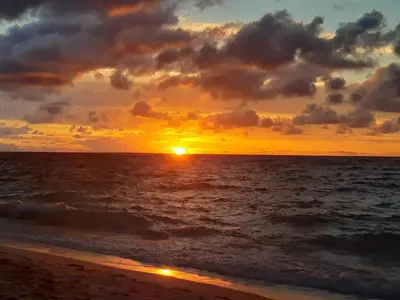 a sunset on the beach with the ocean at Hugos Place Baru in Playa Blanca