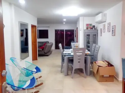 a dining room and living room with a table and chairs at Casa Bita Morales CASA 101 in Las Canoas