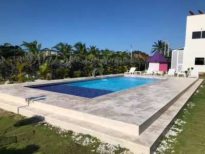 a swimming pool in a yard next to a house at Casa Bita Morales CASA 101 in Las Canoas