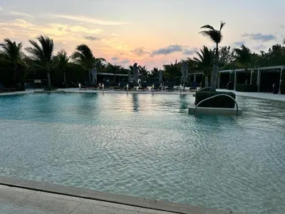 a large swimming pool with a sunset in the background at LUXURY APARTAMENT, MORROS ECO VISTA AL MAR. in Cartagena de Indias