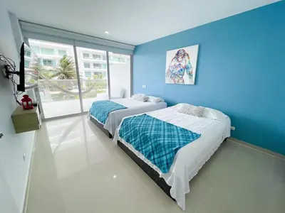 two beds in a room with a blue wall at Apartamento Cartagena Morros Epic in Cartagena de Indias