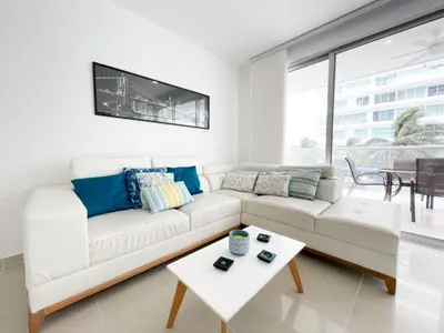 a white living room with a white couch and a table at Apartamento Cartagena Morros Epic in Cartagena de Indias