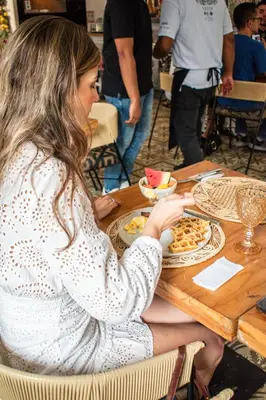 a woman sitting at a table with a plate of food at Casa Noa Colonial Rooms in Cartagena de Indias