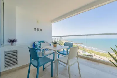 a dining room with a table and chairs with a view of the ocean at Condominio exclusivo nuevo frente al mar Cartagena Beach in Cartagena de Indias