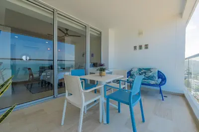 a dining room with blue and white chairs and a table at Condominio exclusivo nuevo frente al mar Cartagena Beach in Cartagena de Indias