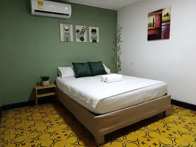 a bedroom with a bed in a room with green walls at Casa vacacional, cerca del aeropuerto in Cartagena de Indias