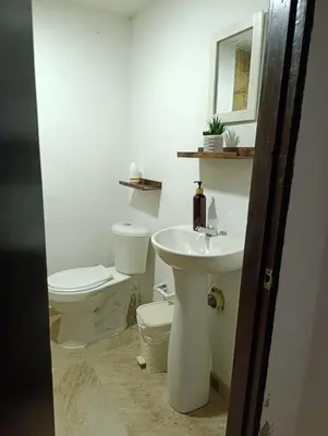 a white bathroom with a toilet and a sink at Casa perla in Cartagena de Indias
