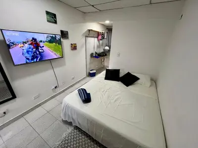 a bedroom with a bed and a flat screen tv at Belcanto Room's in Cartagena de Indias