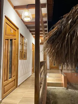 a hallway with a wooden door and a straw roof at Cabaña El Cangrejo Azul - Blue Crab House in San Onofre